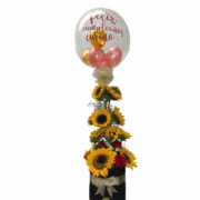 caja de girasoles rosas y globo burbuja